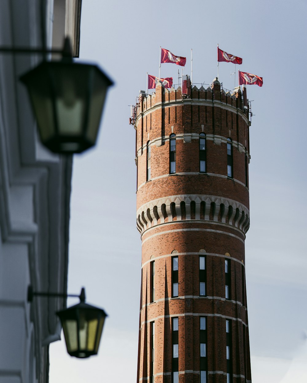 a tall brick tower with flags on top of it