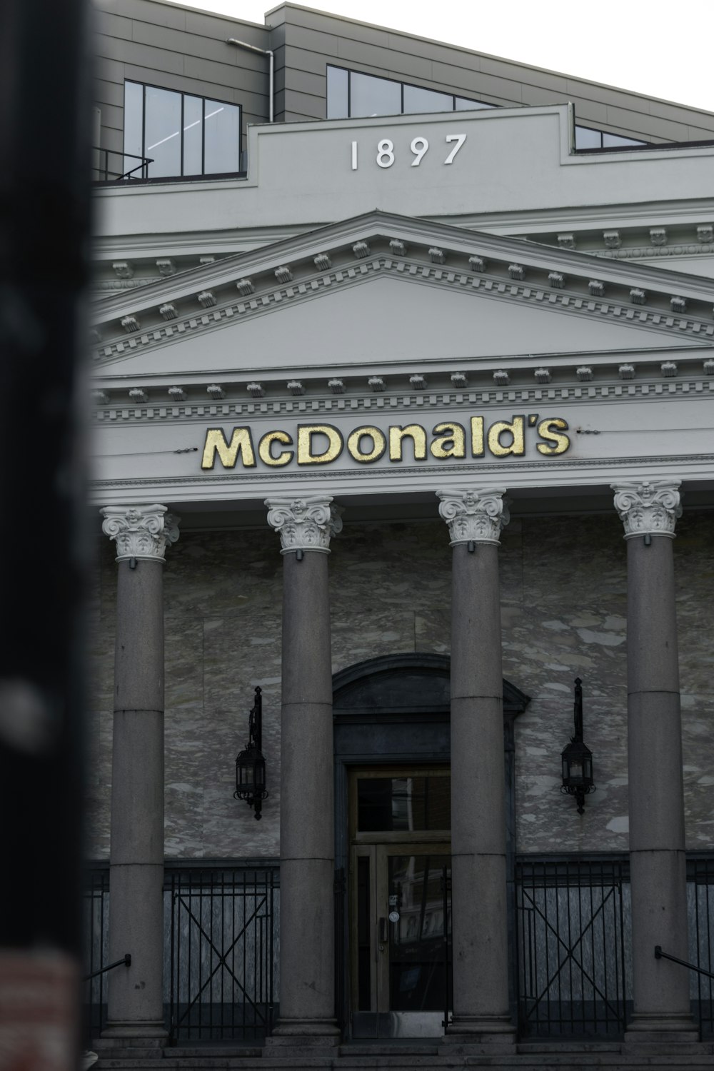 a building with columns and a sign that reads mcdonald's