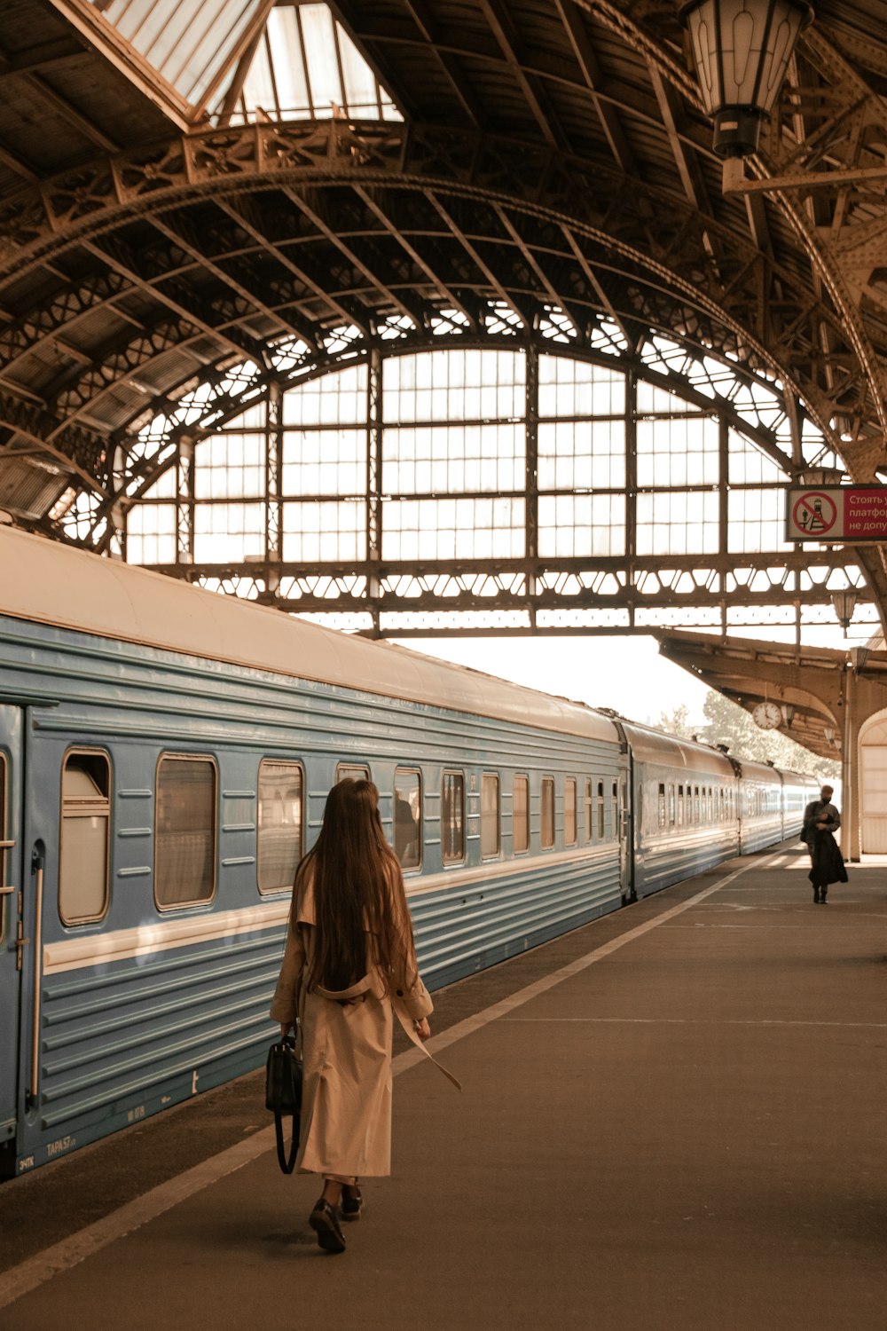 a woman walking on a platform next to a train