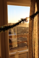 Sunlight streaming through the shop window, illuminating the wooden decorations and clothing racks.