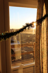 Sunlight streaming through a vibrant glass suncatcher hanging in a cozy window