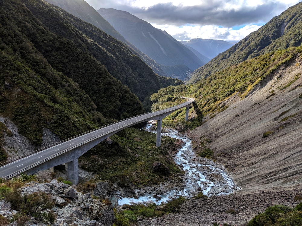 a long bridge over a river in the middle of a mountain