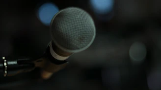 Close-up of a headset microphone with a blurred office background.