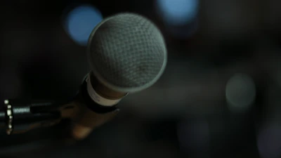 Close-up of a headset microphone with a blurred office background.