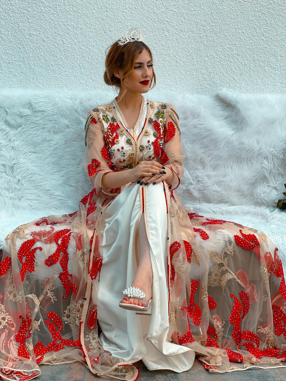 a woman in a red and white dress sitting on a couch