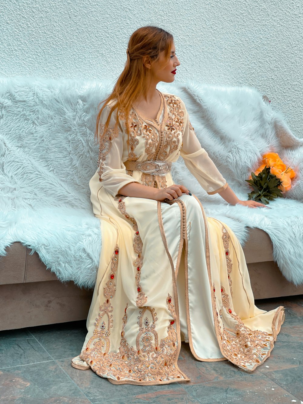 a woman sitting on a bench in a long dress