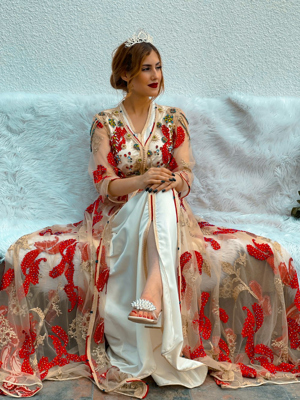 a woman in a red and white dress sitting on a couch