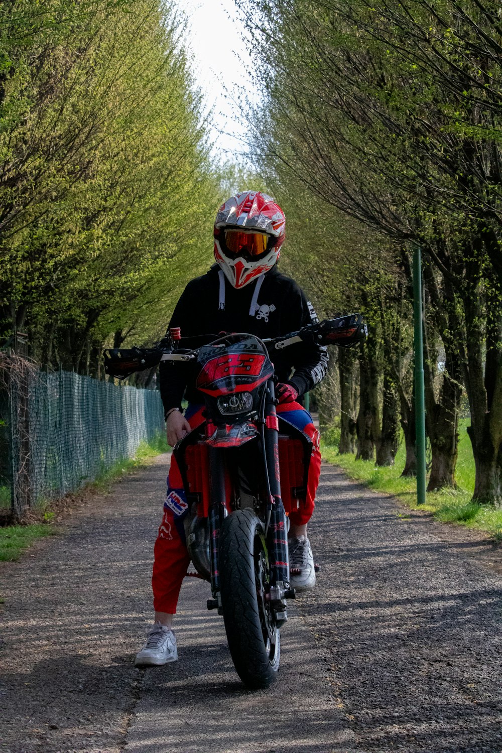 a man riding a motorcycle down a dirt road