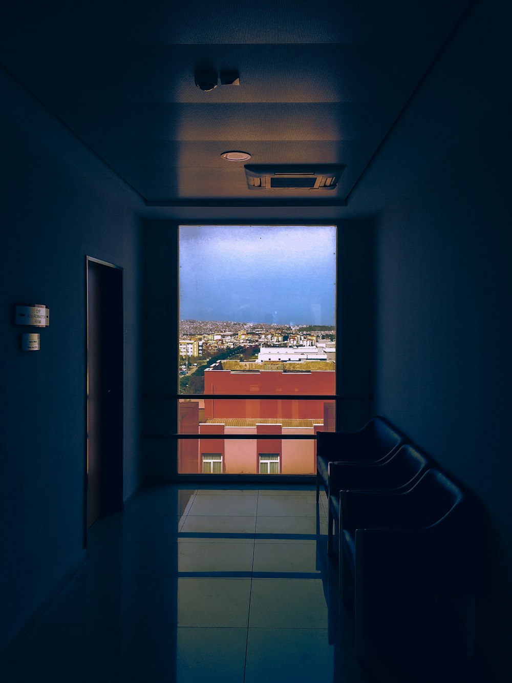 an empty hallway with a view of a city
