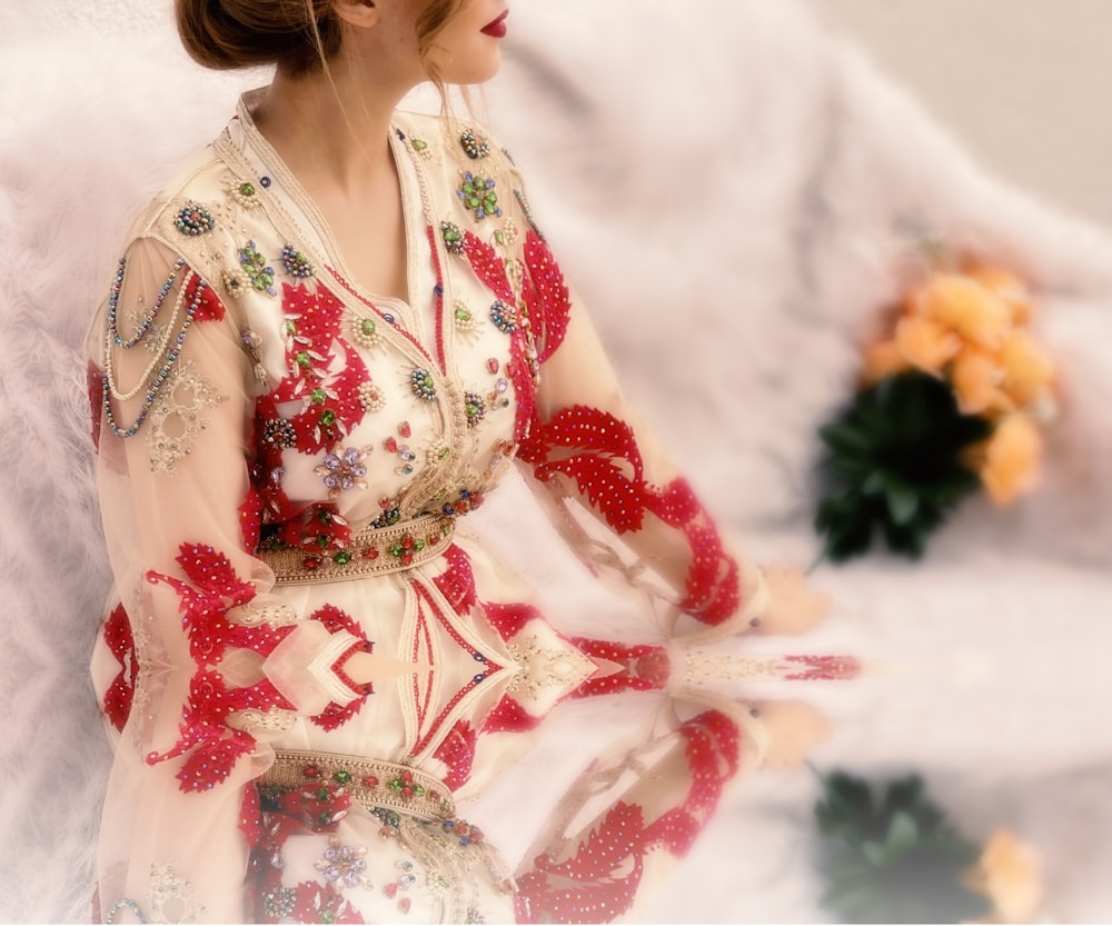 a woman in a red and white dress sitting down