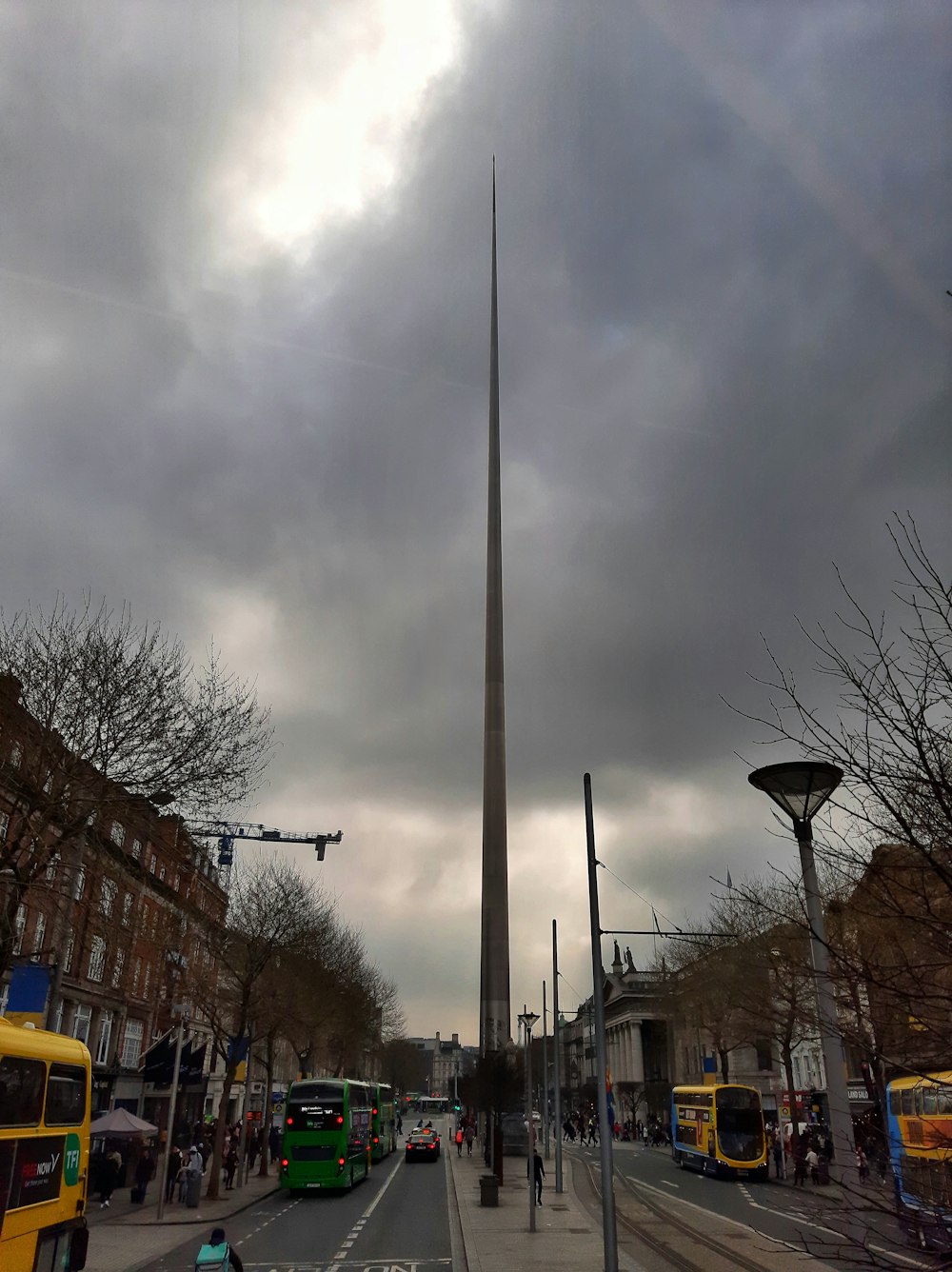 Ein sehr hoher Obelisk, der über einer Stadtstraße thront