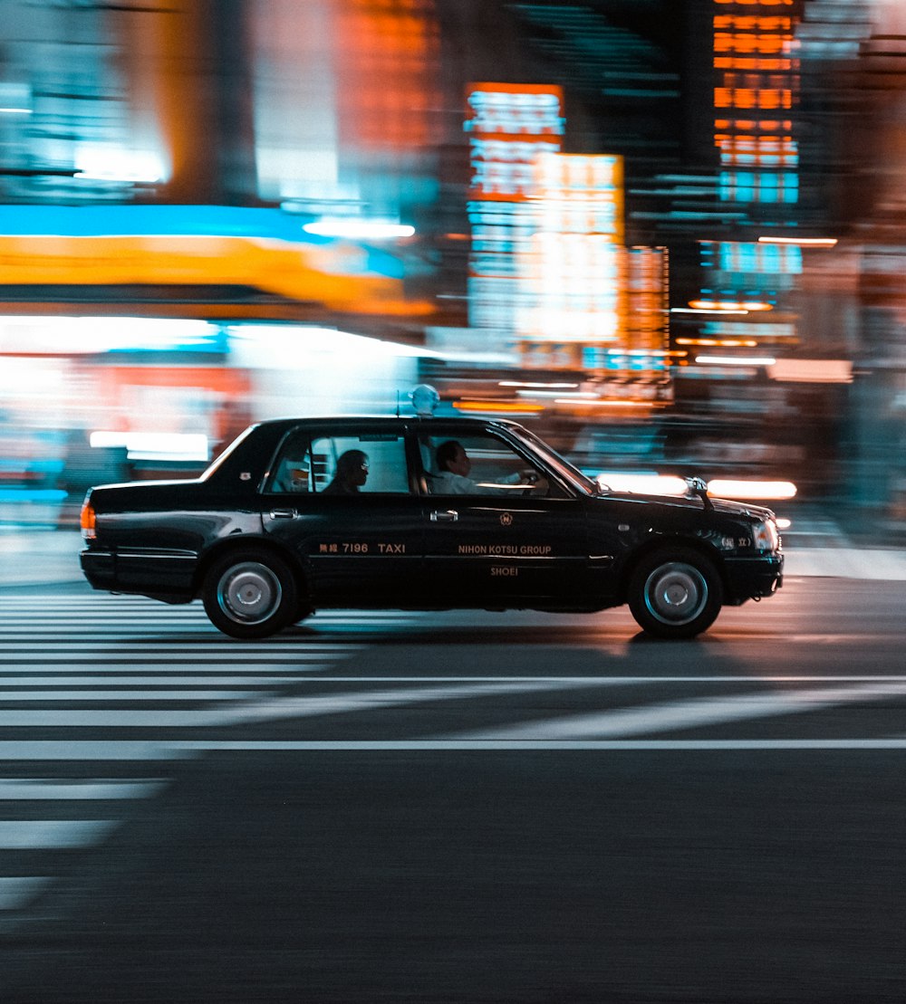 a taxi cab driving down a city street at night