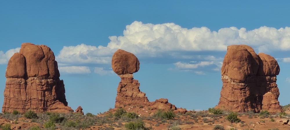 a group of rocks in the desert under a cloudy sky