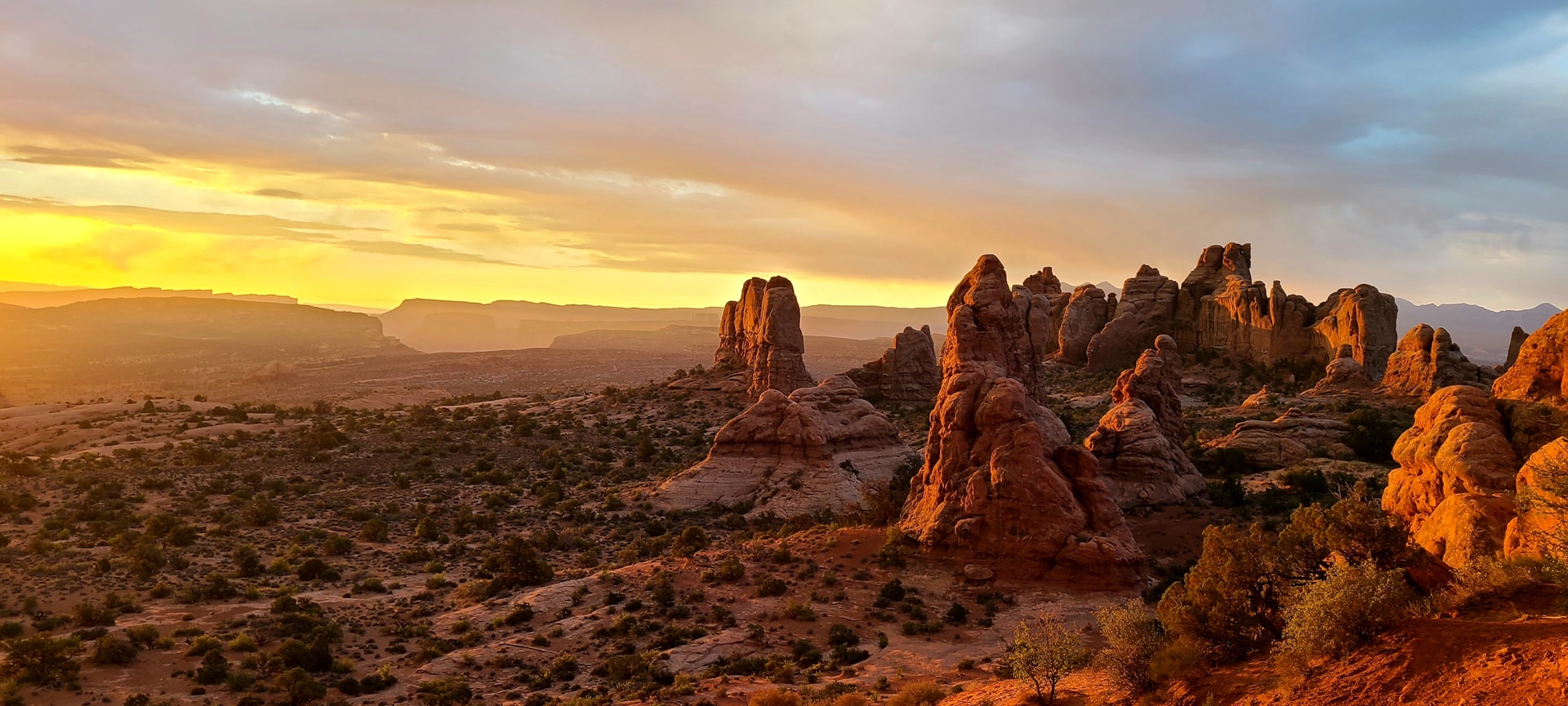 the sun is setting over the mountains in the desert