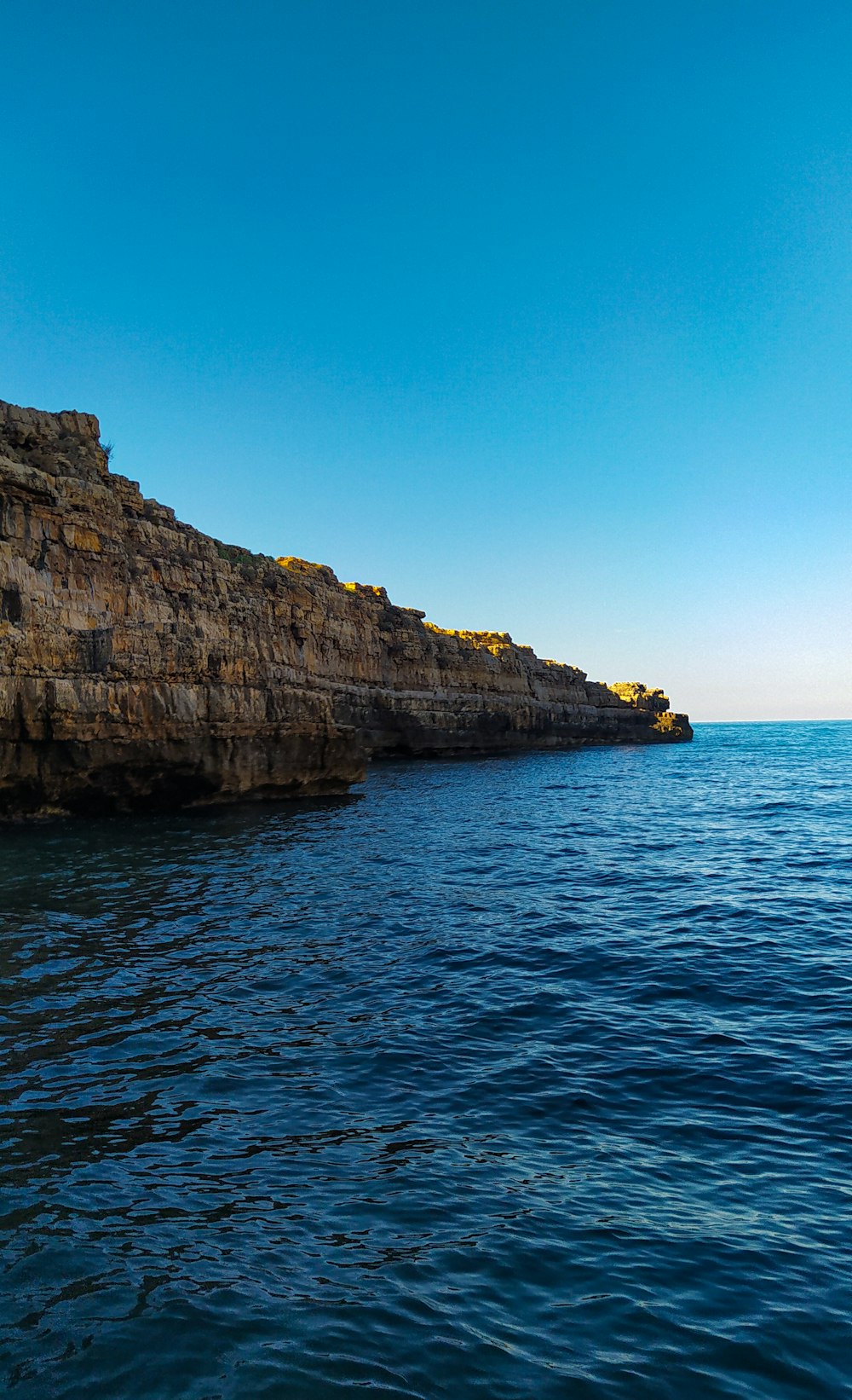 a large body of water next to a rocky cliff