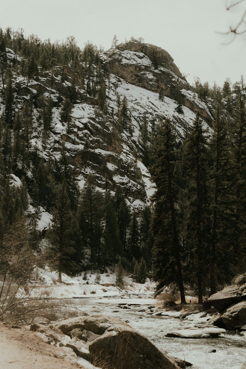 a man riding a snowboard down a snow covered road