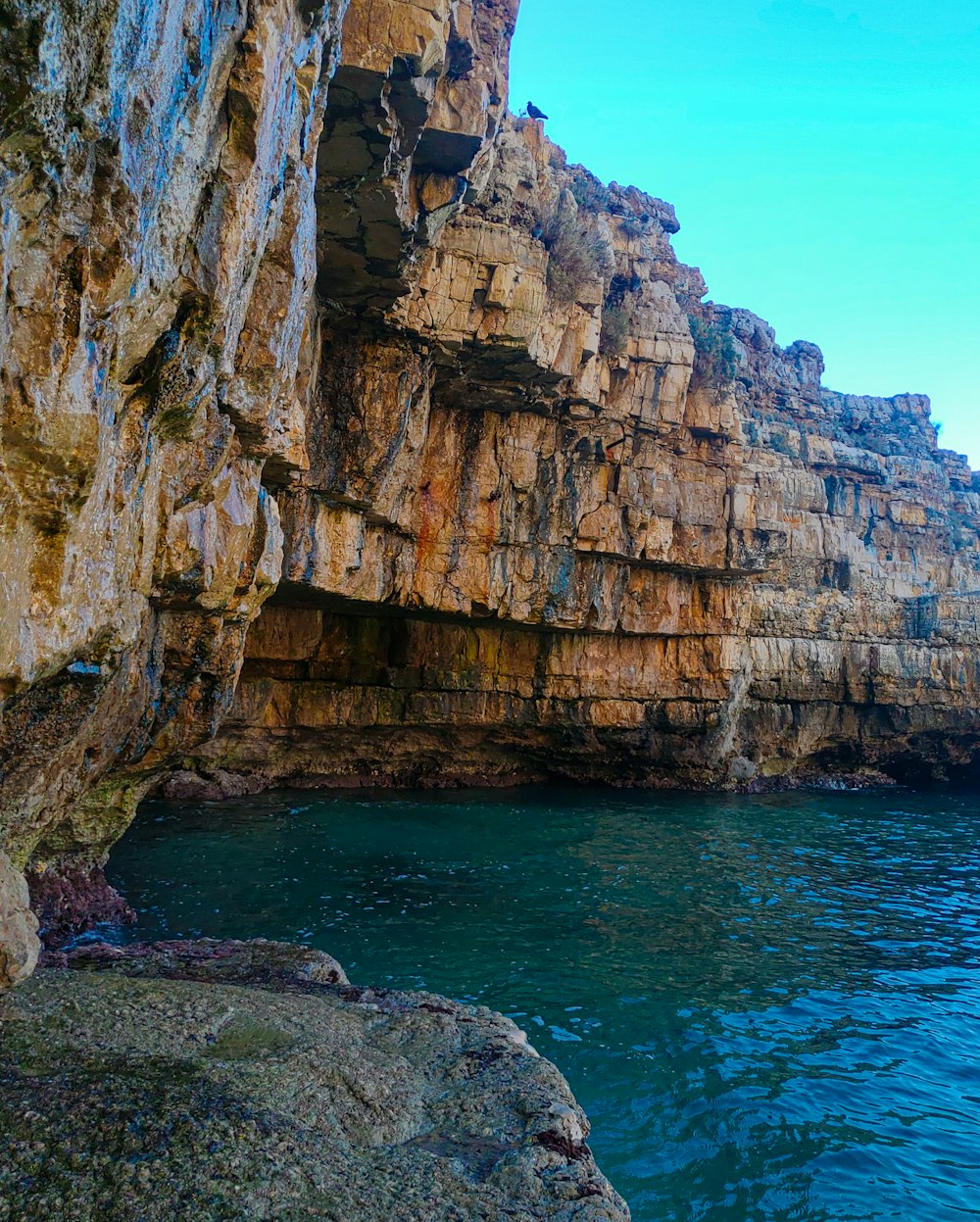 a body of water near a rocky cliff