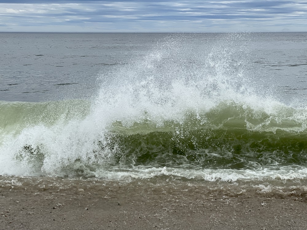 a wave crashes on the shore of a beach