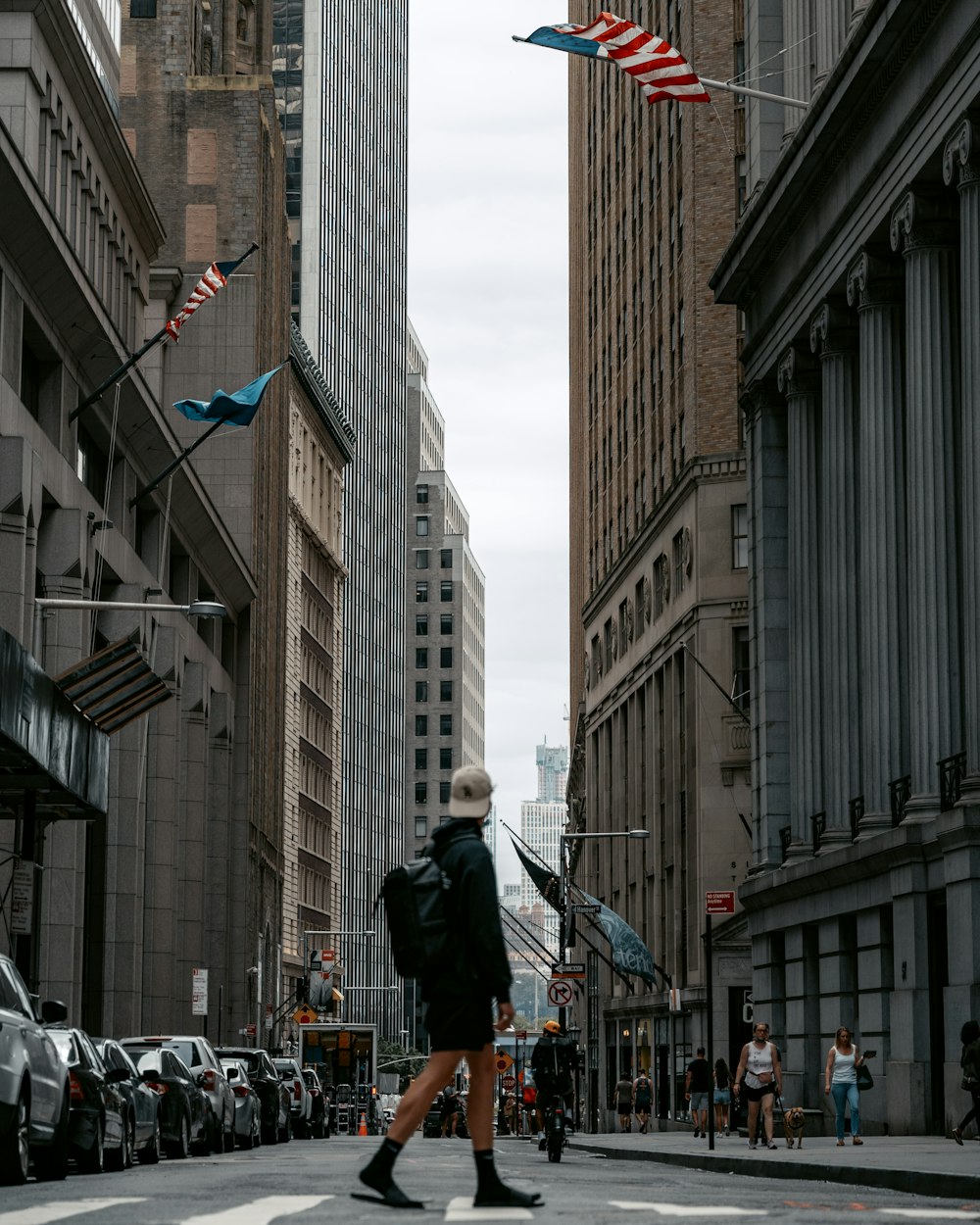 a person walking across a street in a city