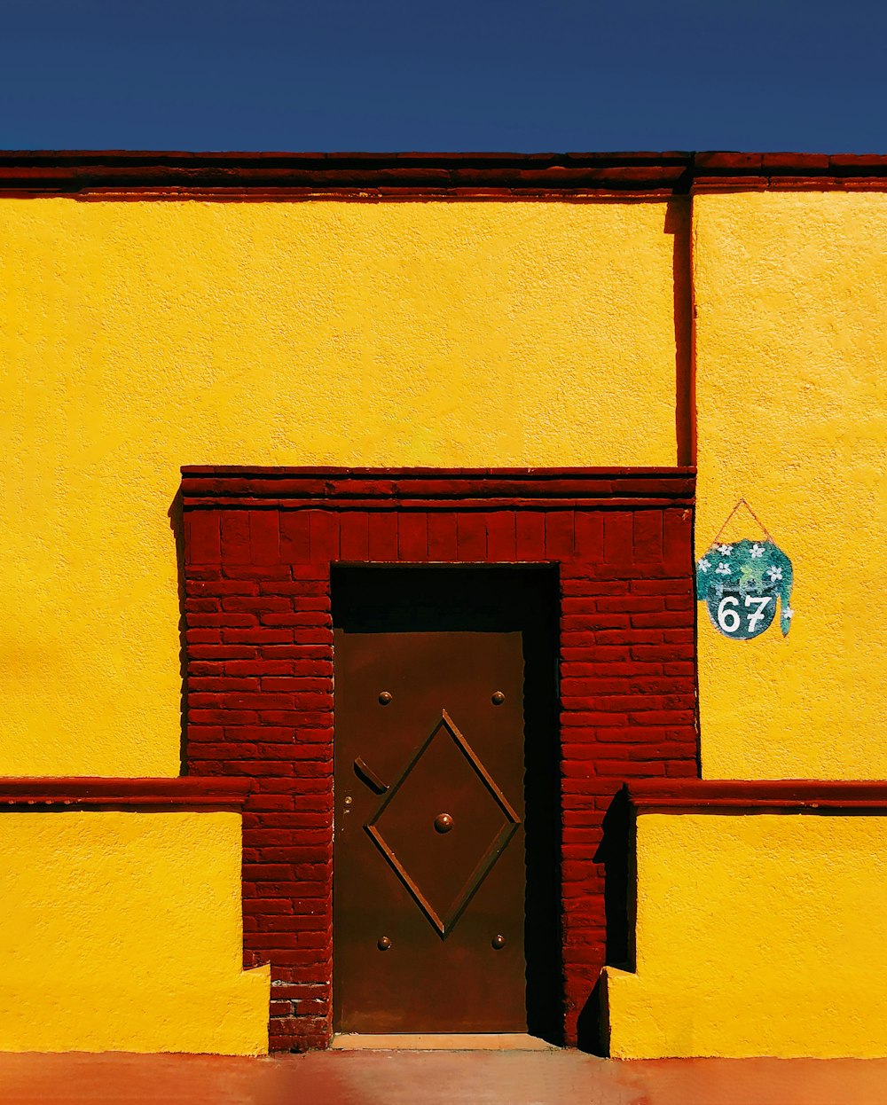 Un edificio amarillo y rojo con una puerta marrón