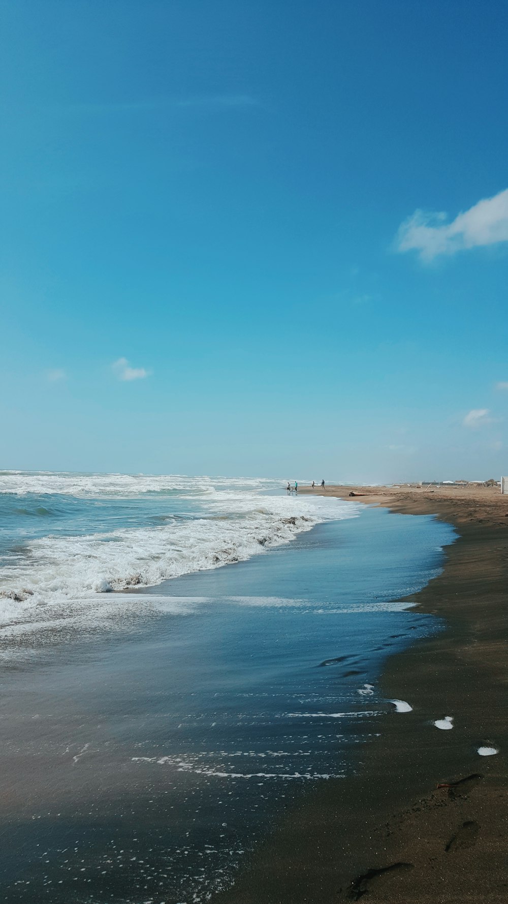 a sandy beach with waves coming in to shore