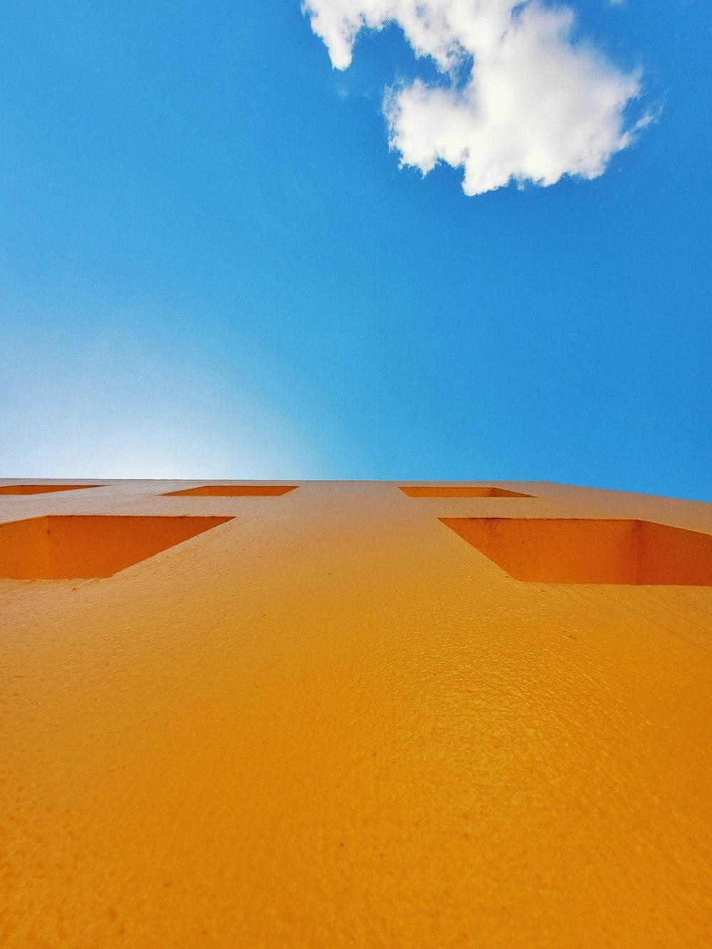 a blue sky with a few clouds above a sand dune