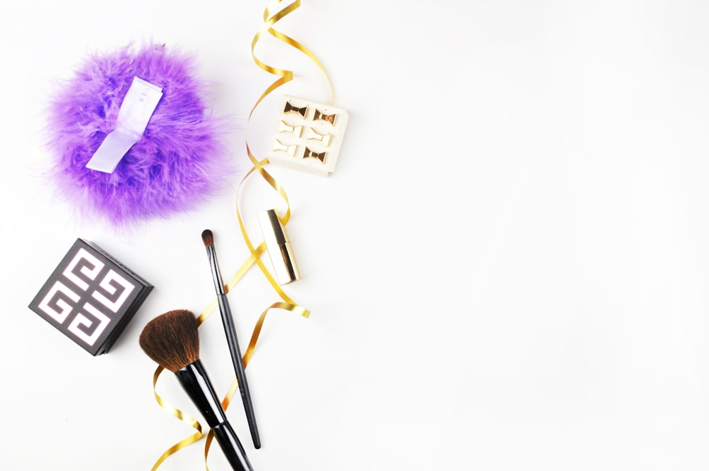 a white table topped with makeup brushes and other items