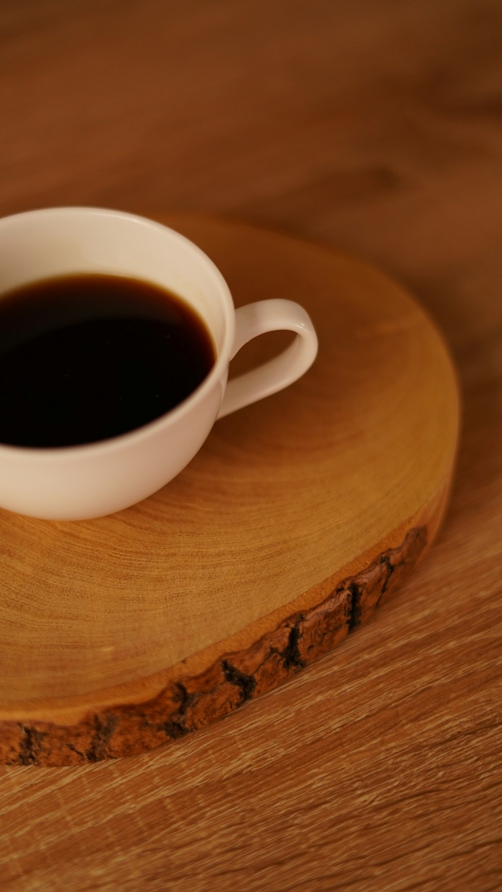 a cup of coffee sitting on top of a wooden table