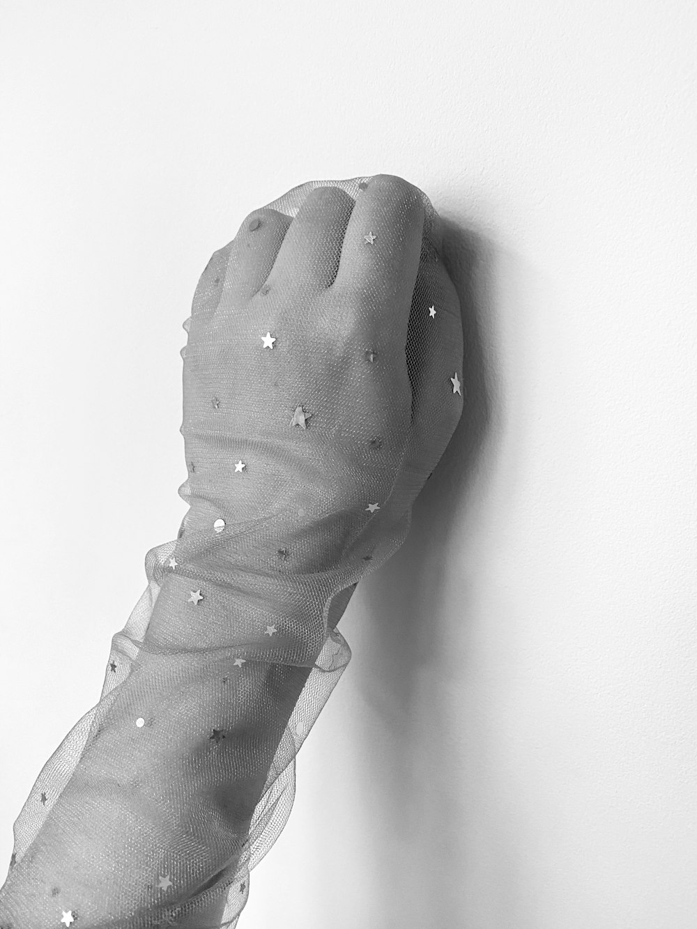 a black and white photo of a glove with stars on it