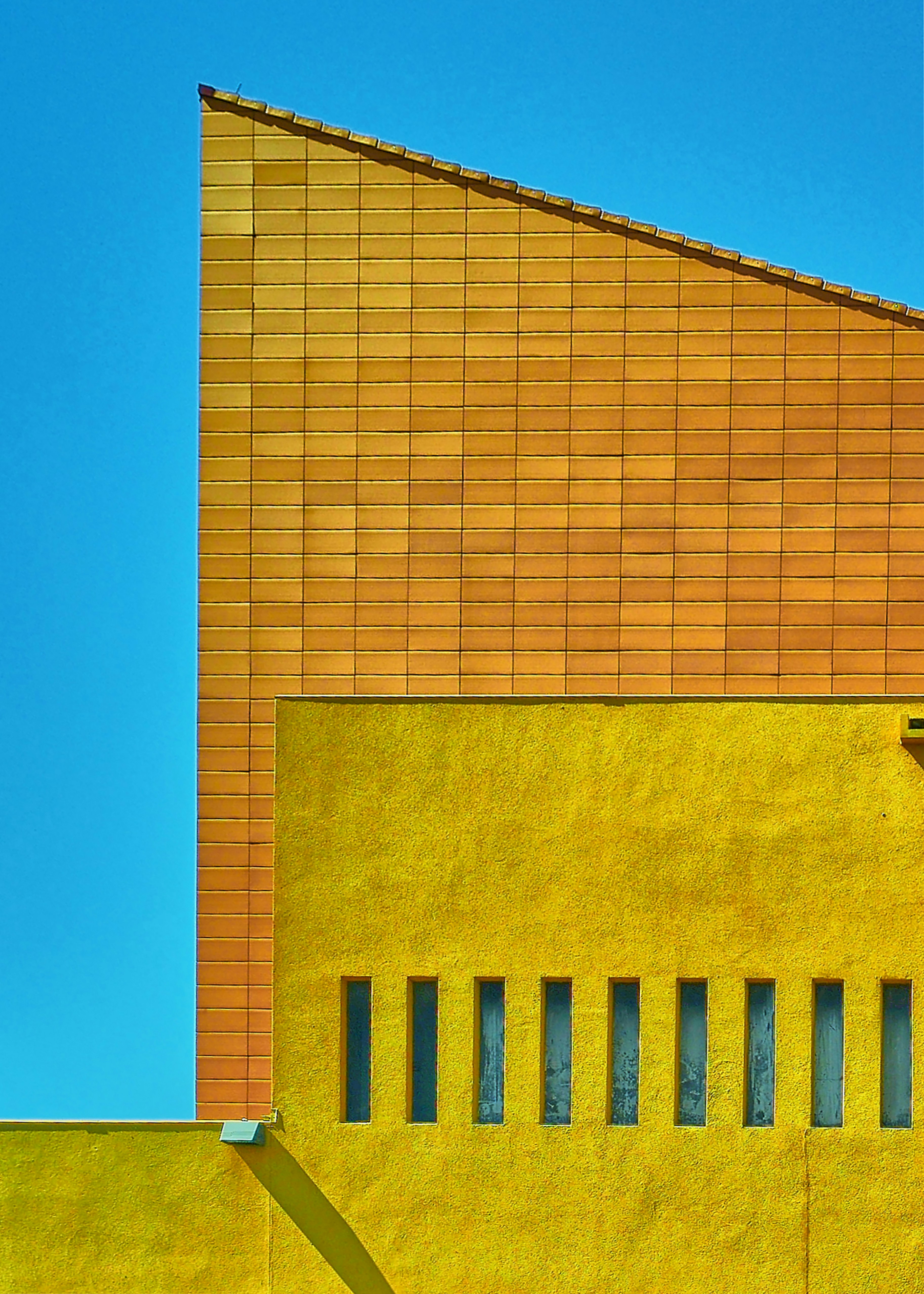 um edifício amarelo com um relógio ao lado dele