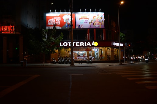 a store front at night with a lotteria sign lit up
