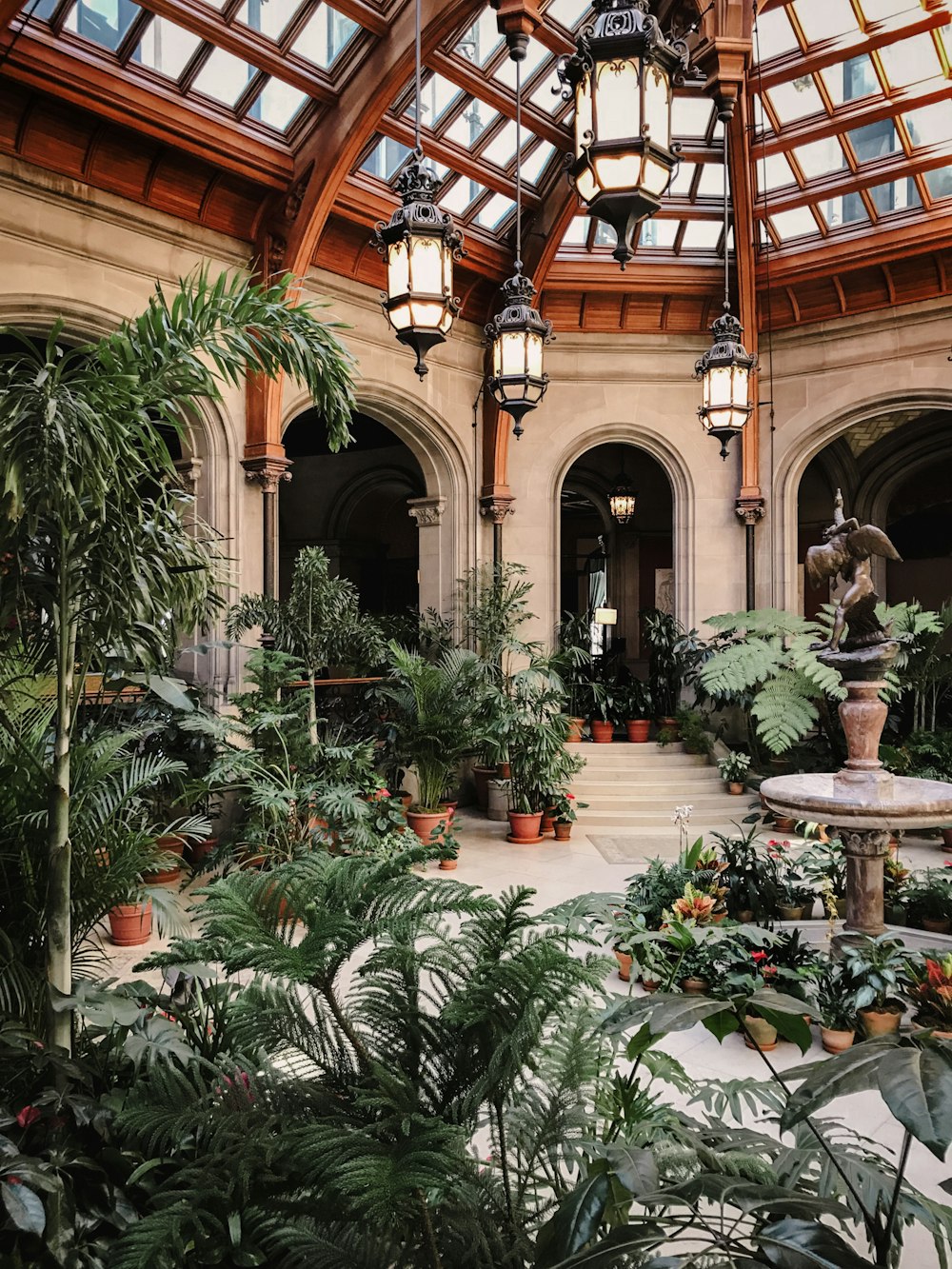 a large building with a fountain surrounded by plants