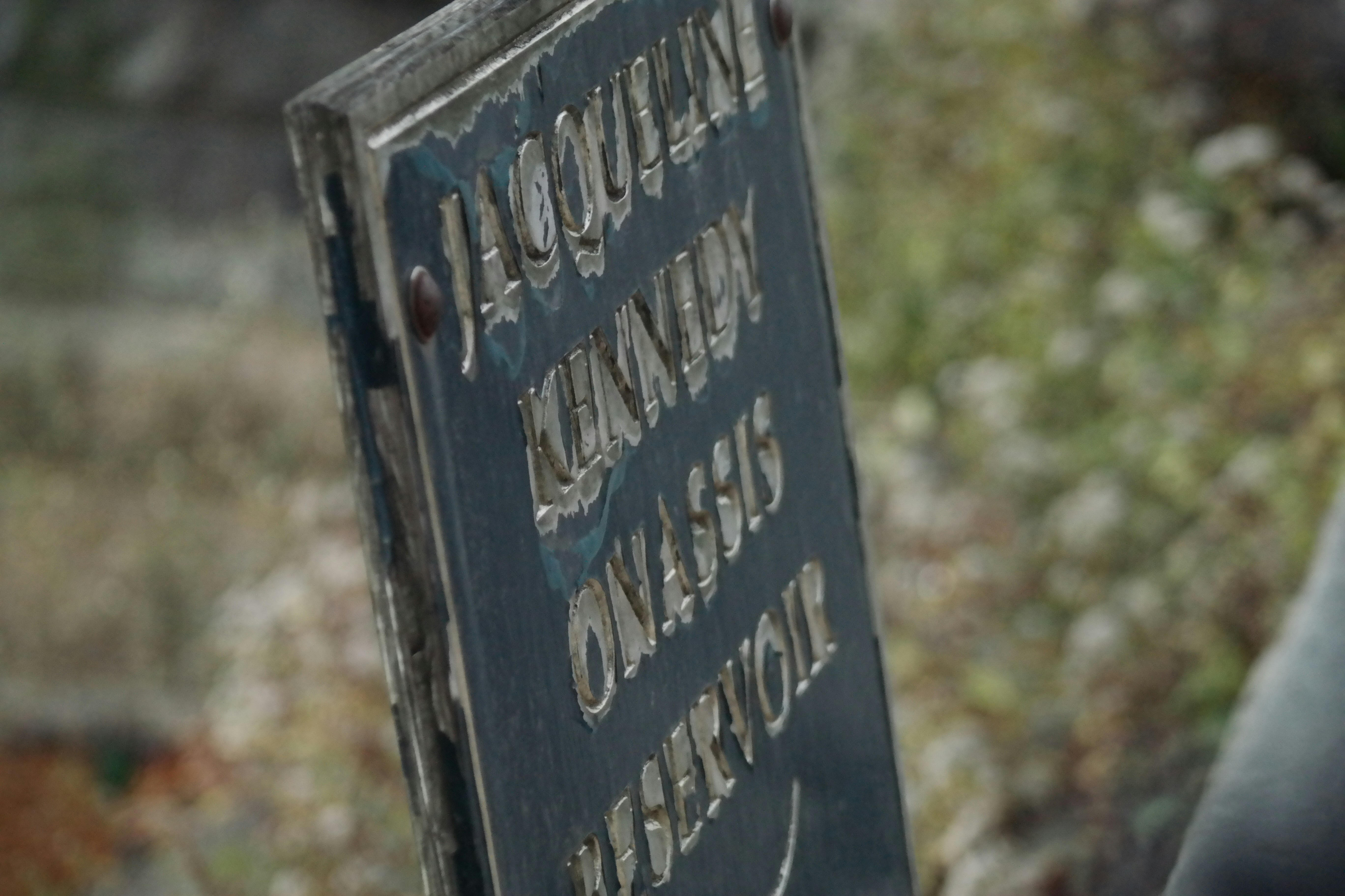 Close-up of vintage sign showing original paint and embossed lettering detail