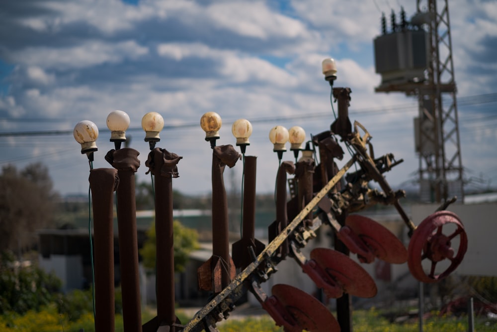 a row of old fashioned street lamps next to a fence