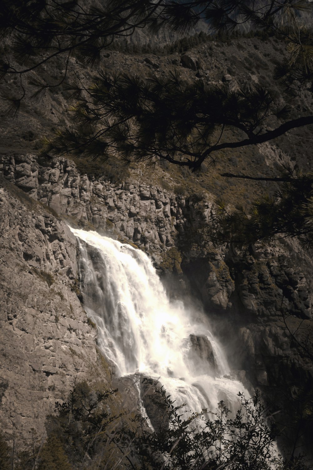 a very tall waterfall in the middle of a forest