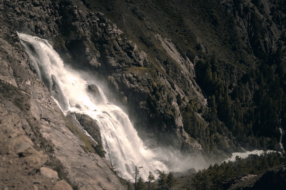 a waterfall is seen from the side of a mountain