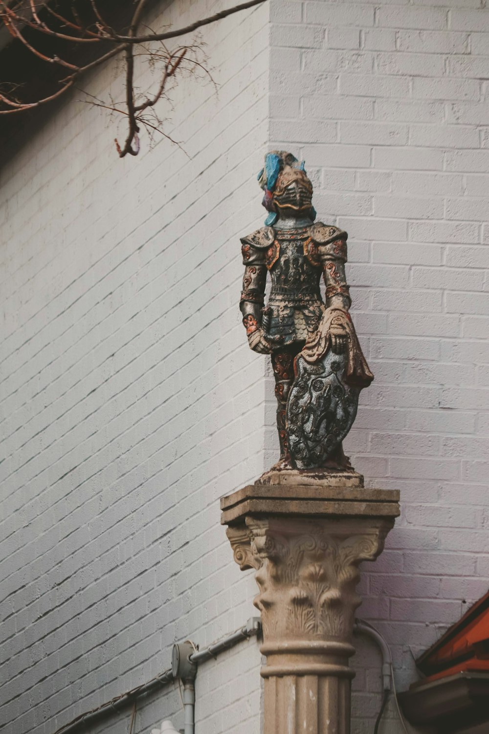 uma estátua de um homem em um pedestal na frente de um edifício