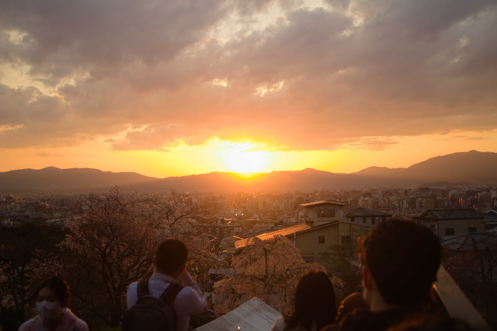 a group of people sitting on top of a wooden bench