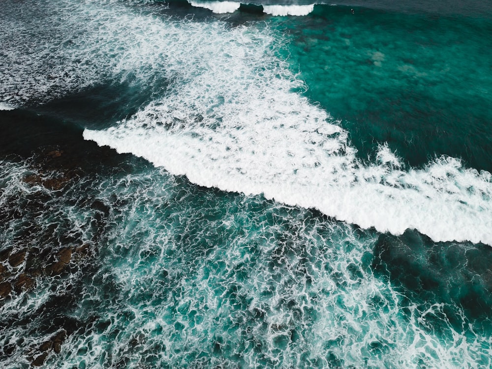 an aerial view of the ocean with waves