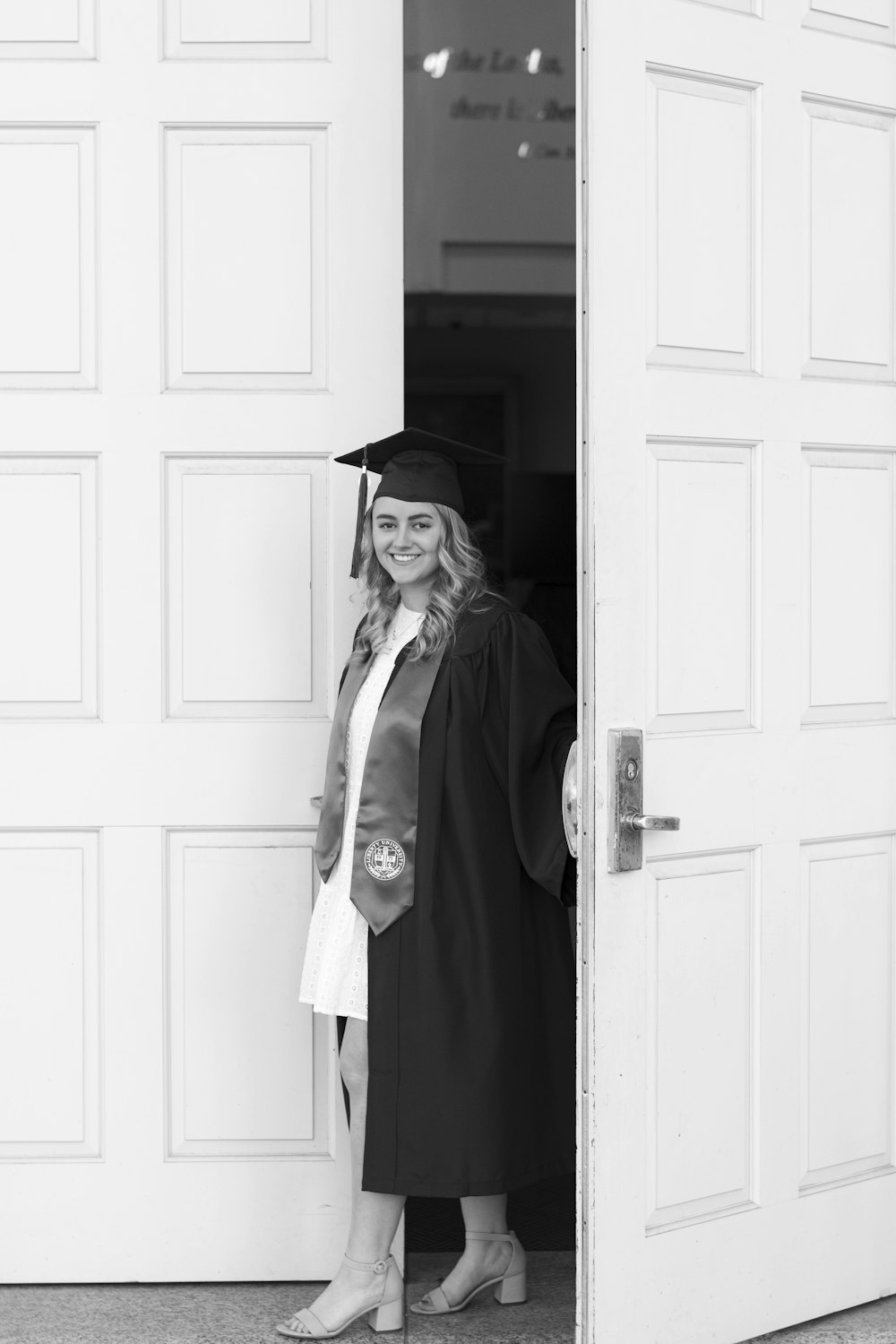 a woman in a cap and gown standing in a doorway