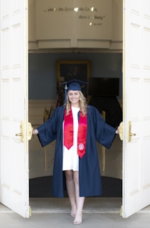 a woman in a graduation gown standing in a doorway