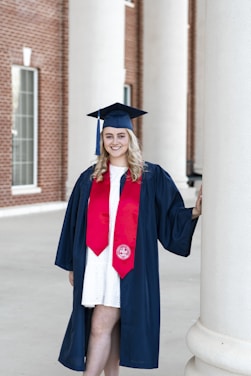 a woman in a graduation gown and cap posing for a picture