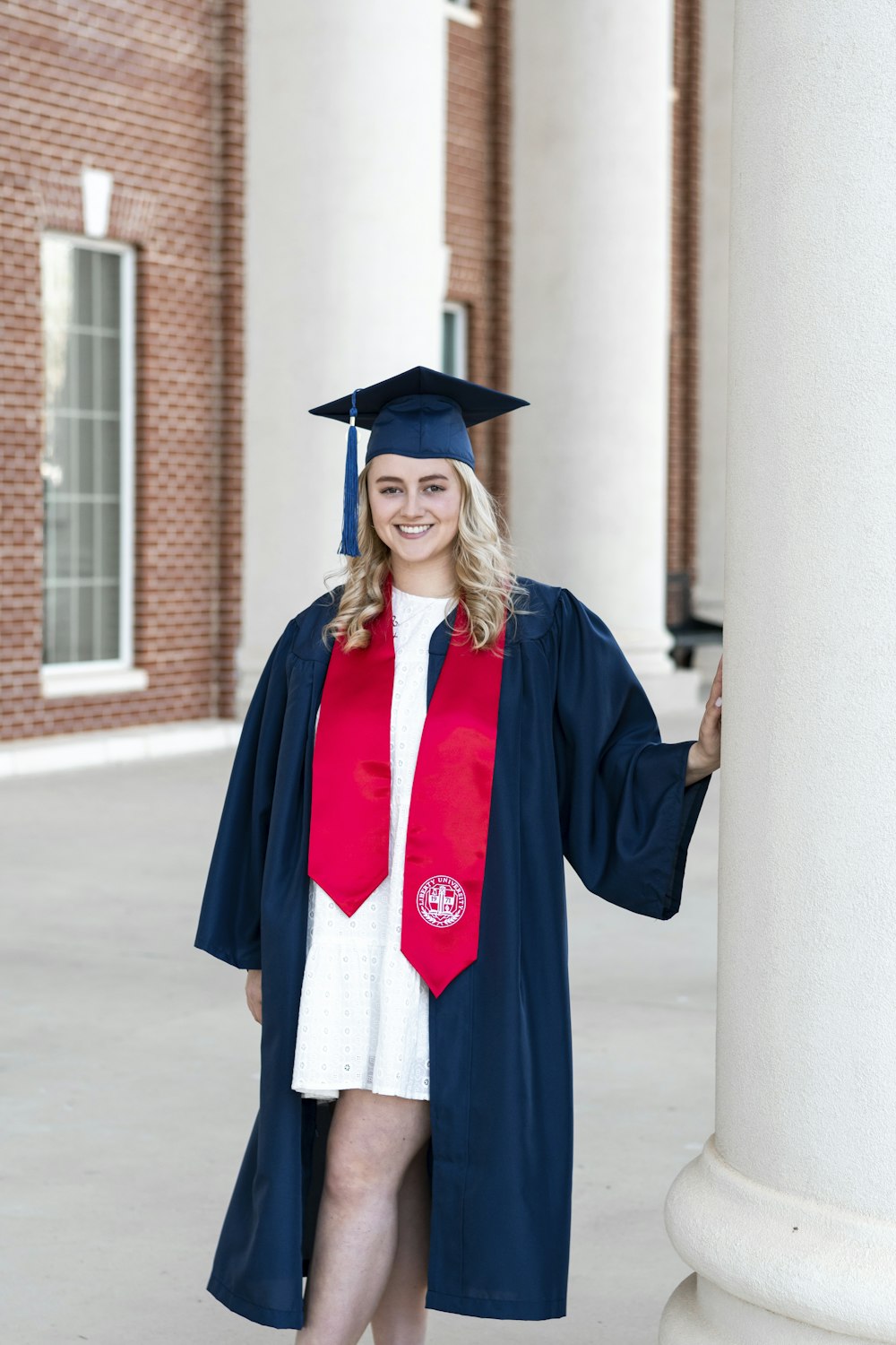 Une femme en robe de graduation et casquette posant pour une photo