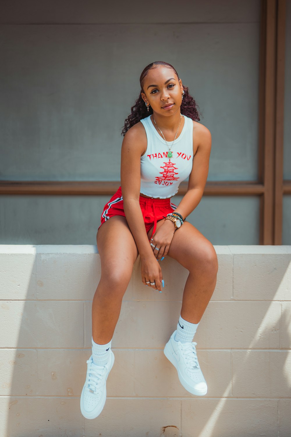 a woman sitting on a ledge with her legs crossed