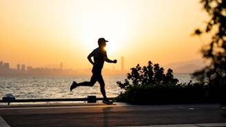 a man running on the beach at sunset