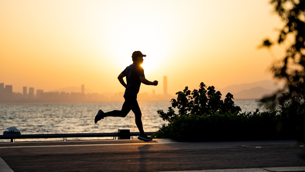 a man running on the beach at sunset