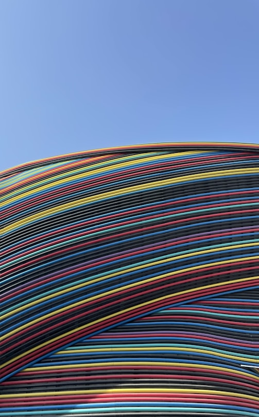 a large stack of multicolored wires against a blue sky