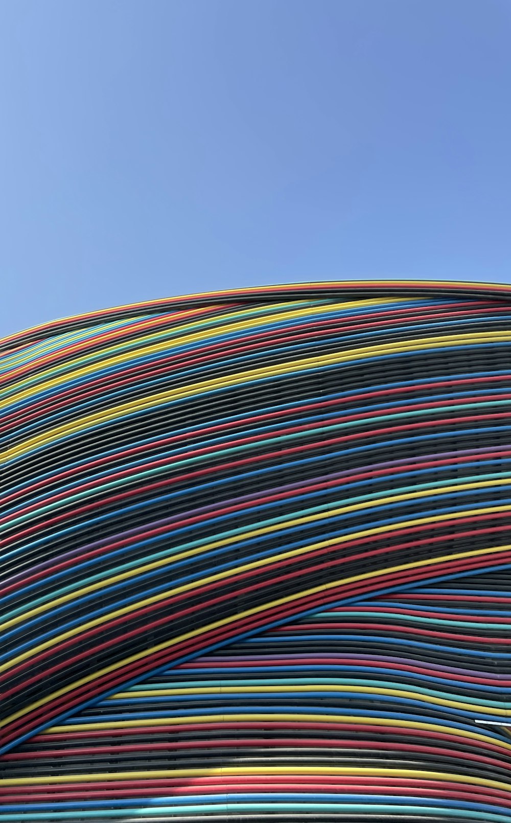 a large stack of multicolored wires against a blue sky