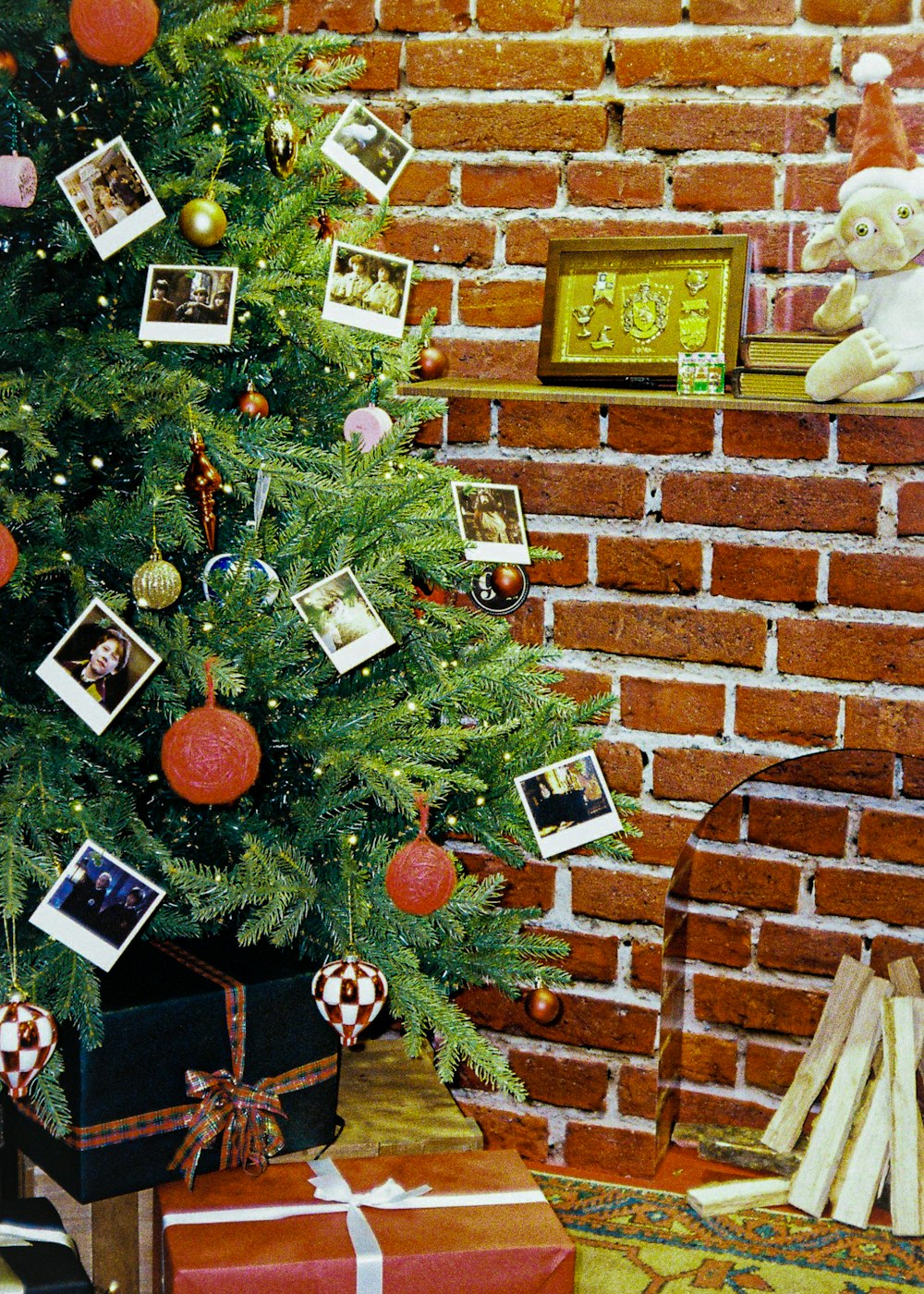 a christmas tree with pictures on it next to a brick wall