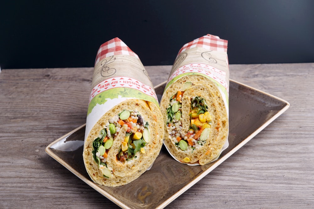 two burritos on a plate on a wooden table